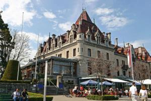 a large building with people sitting outside of it at Le Yanis in Lausanne