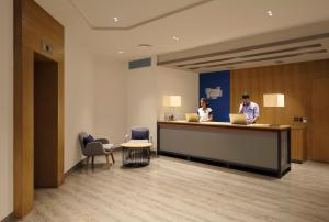 two people sitting at a reception desk with laptops at Holiday Inn Express Pune Pimpri, an IHG Hotel in Pune