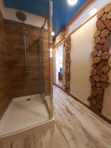 a walk in shower in a room with wood at Karibuni - Familiar Lodging & Private Spa in Villarrica