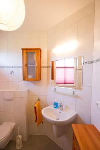 ein weißes Badezimmer mit Waschbecken und Toilette in der Unterkunft Ferienhaus Iris in Zempin
