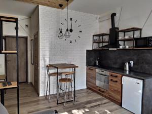 una cucina con bancone e tavolo con sgabelli di Loft возле парка, стадиона и озера a Ivano-Frankivsʼk