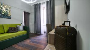 una sala de estar con un sofá verde y una maleta en Home Suites Giolitti, en Roma