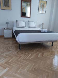 a bedroom with a bed and a wooden floor at Chalet Avila Rooms in Madrid +4 photos