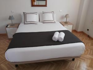 a bedroom with a large bed with two white towels on it at Chalet Avila Rooms in Madrid