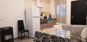 a kitchen with a couch and a table and a refrigerator at Casa Marta in Setenil