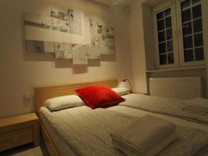 a bedroom with a bed with a red pillow at Grand-Tourist Amber Center Apartments in Gdańsk
