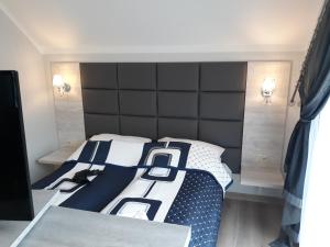 a bedroom with a bed with a black headboard at Apartamenty Pod Skrzycznem in Szczyrk