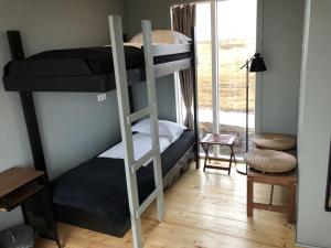 a bed room with a bunk bed and a desk at Glacier View Guesthouse - Hrífunes in Hrífunes 
