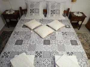 ein Bett mit einer grau-weißen Decke und Kissen in der Unterkunft Le Ruchoz in Lausanne