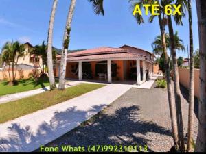 a house with palm trees in front of it at Pousada Parque Praia in Penha +15 photos