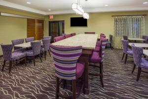 une salle de conférence avec une grande table et des chaises violettes dans l'établissement Holiday Inn Express Hotel & Suites St. Paul - Woodbury, an IHG Hotel, à Woodbury