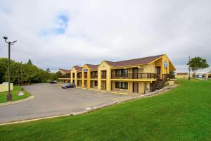 a large yellow building with a parking lot at Travelodge by Wyndham Appleton in Appleton