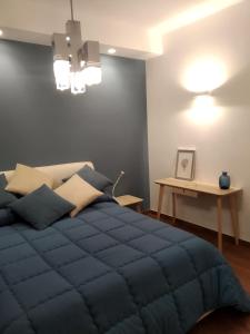 a bedroom with a blue bed and a table at My place in Bari