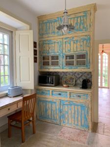 a kitchen with blue cabinets and a table and a chair at Entire House - Romantic Vintage Cottage in Sintra