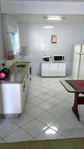 a kitchen with white counters and white appliances at Gênesis Beach Hostel! Quartos compartilhados e privativos na Pinheira in Palhoça