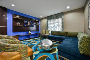 ein Wohnzimmer mit einem blauen Sofa und Stühlen in der Unterkunft Holiday Inn Express & Suites Forrest City, an IHG Hotel in Forrest City