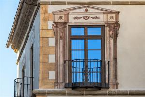 a window on the side of a building at Palacio Solecio, a Small Luxury Hotel of the World in M&aacute;laga