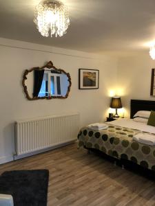 a bedroom with a bed and a mirror on the wall at Trinity Guest House in Hartlepool