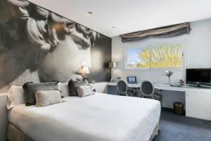 馬德里的住宿－全球亞西斯加勒蒂亞旅館，卧室配有一张大床,墙上挂有绘画作品