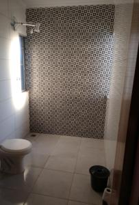 a bathroom with a toilet and a tiled shower at Casa botucatu in Botucatu +3 photos