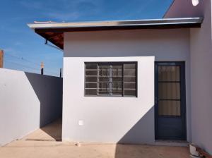a white house with a window and a door at Casa botucatu in Botucatu