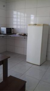 a kitchen with a white refrigerator in a room at Casa botucatu in Botucatu