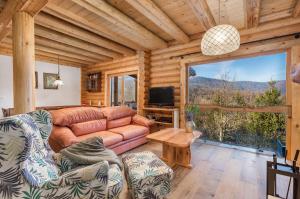 a living room with a couch and a large window at Mountain family home Nola Ivano in Delnice