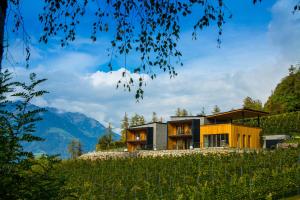 una casa en una colina con montañas en el fondo en Romantik Chalet im Weingut Eichenstein en Merano