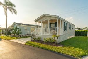 a small white house with a porch on a street at Buttonwood Bay in Sebring
