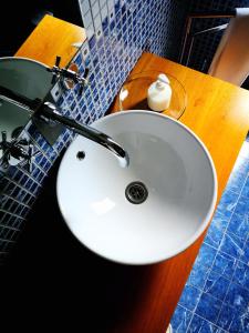 lavabo blanco en el baño con espejo en Moinho da Ponte Velha, en Bragança