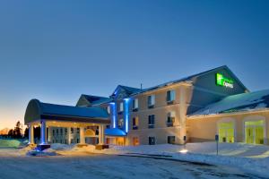 un hotel en la nieve por la noche en Holiday Inn Express Hotel & Suites Cadillac, an IHG Hotel, en Cadillac