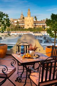 - une table sur un balcon avec vue sur le port dans l'établissement Casa de Triana Luxury Suites by Casa del Poeta, à Séville