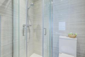 uma casa de banho com uma cabina de duche em vidro e um WC. em Admiral Hotel at Park Avenue em Londres