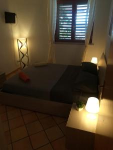 a bedroom with a bed and a window and lights at La Casita Il Poggio Del Sole in Letojanni