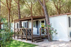 a tiny house with a porch and a tree at Salinello Village in Tortoreto Lido