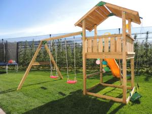 un parque infantil de madera con tobogán y columpios en Mairhof en Missiano