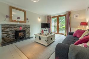 a living room with a couch and a fireplace at Curlew's Cwtch in Wadebridge