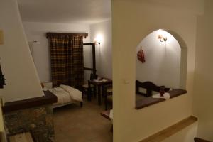 ein Zimmer mit einem Spiegel und ein Wohnzimmer mit einer Couch in der Unterkunft Lasinthos Eco Park in Agios Georgios