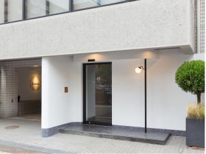 a building with a glass door on a sidewalk at THE HOTELS HAKATA KASANE Bayside in Fukuoka