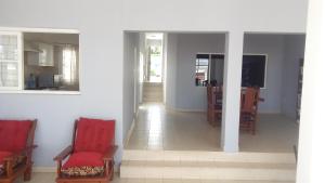 a hallway with red chairs and a dining room at Buen Descanso in Salta