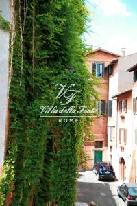 a ivy covered wall next to a street with cars at Villa della Fonte in Rome