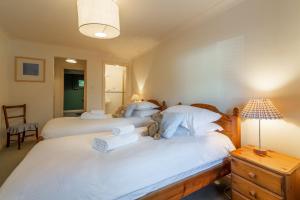 duas camas num quarto com dois ursinhos de peluche em Keepers Cottage em Wadebridge