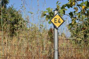 a yellow sign on a pole next to a fence at Lasinthos Eco Park in Agios Georgios