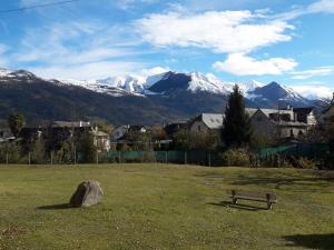 un banco en un campo con montañas en el fondo en Charmant T2 rénové RDC Résidence quartier pavillonnaire en Argelès-Gazost