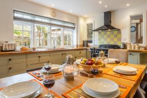 a kitchen with a wooden table with glasses of wine at No2 The Fish Cellars in Port Isaac