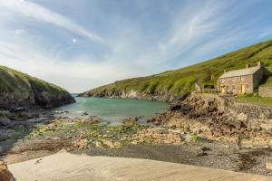 une maison sur la rive d'une masse d'eau dans l'établissement No2 The Fish Cellars, à Port Isaac