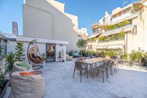 un patio al aire libre con mesa de madera y sillas en Athens Hub Hostel, en Atenas