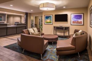 sala de estar con sillas y TV de pantalla plana en Candlewood Suites Sierra Vista, an IHG Hotel, en Sierra Vista