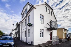 a white building with a car parked in front of it at Guesthouse Andrea in Reykjavík