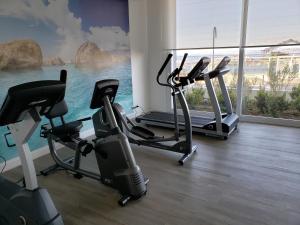 een fitnessruimte met cardio-apparatuur in een kamer met een raam bij DEPARTAMENTO EDIFICIO MARES DE MONTEMAR in Concón